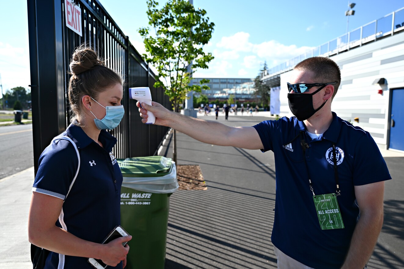 Kaneen Gomez, dietician for Hartford Athletic, gets her temperature taken by volunteer Chris Kelly before entering Dillon Stadium.  